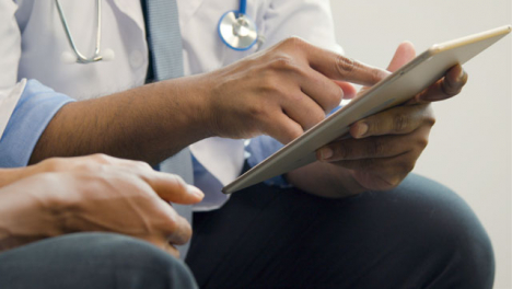 Doctor-Using-Tablet-Whilst-Talking-to-Patient