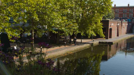 Panning-Shot-of-Elderly-Man-Walking-Next-to-Canal-In-Birmingham-